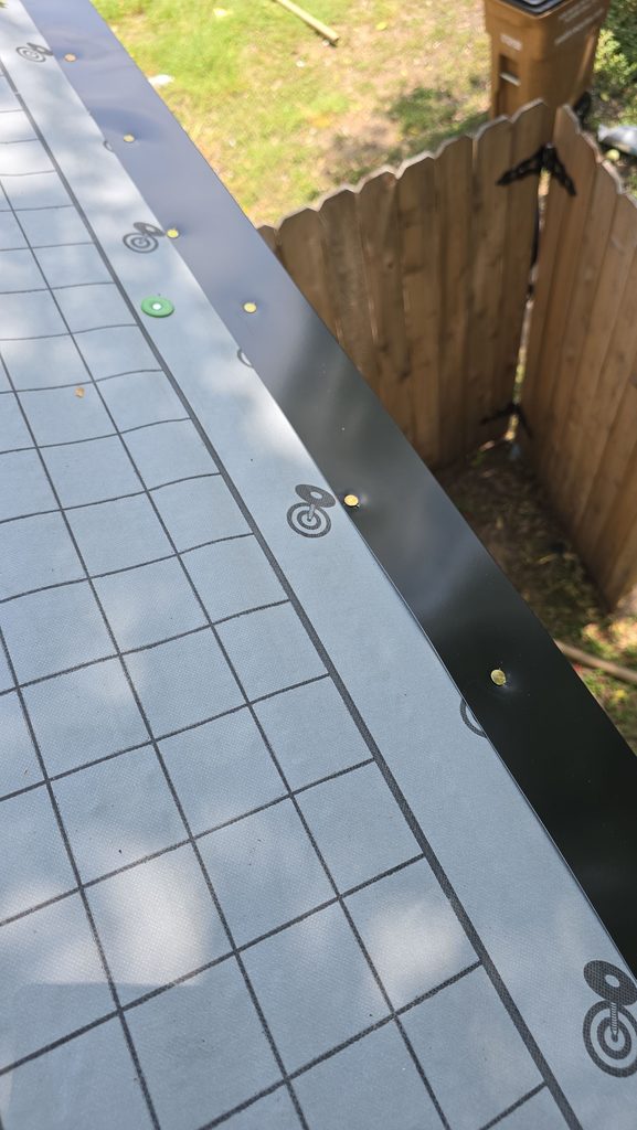 Synthetic underlayment with cap nails and custom black Kynar-coated drip edge along the eave