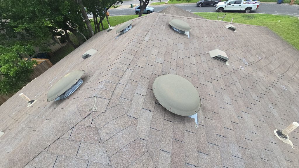 Hail-damaged roof with old shingles and vents before replacement in Turtle Rock Estates, Northwest Austin