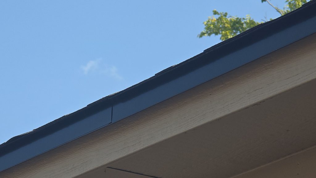 Custom black 24-gauge Kynar-coated drip edge on the finished roof, seen from the ground