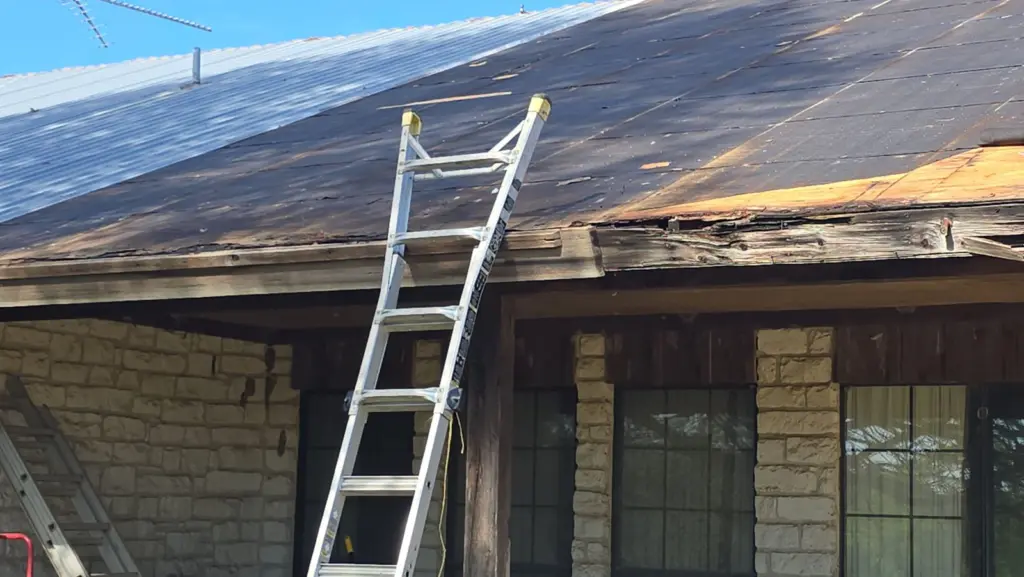 Rotted fascia and damaged plywood at the eave after the old metal was removed