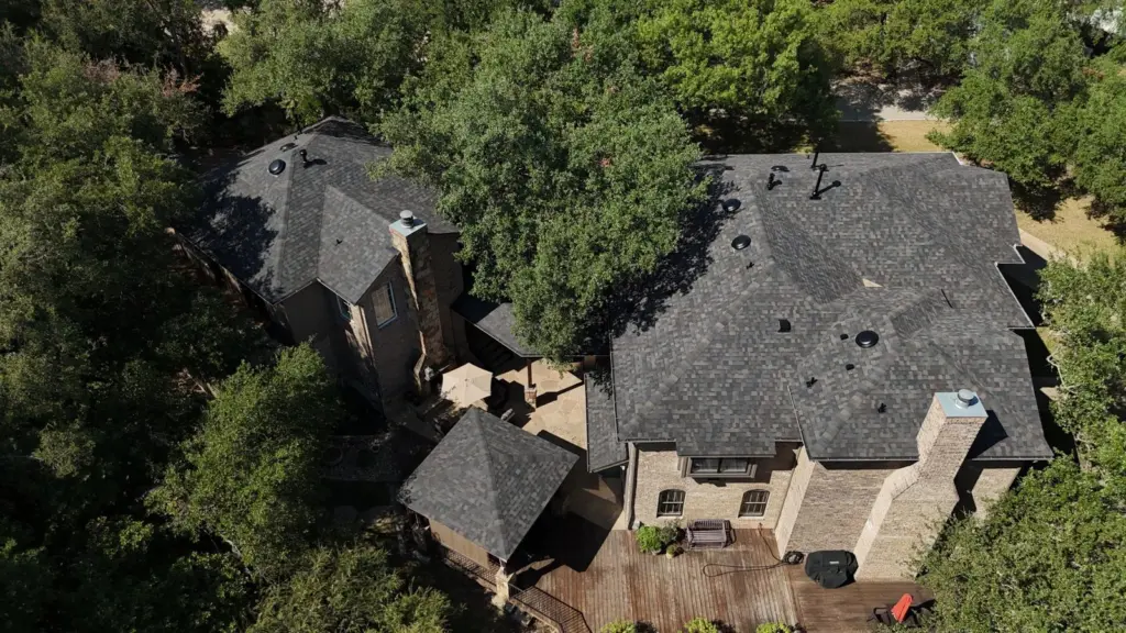 Rear aerial view of a West Lake Hills home and detached garage with new Owens Corning Duration Designer Black Sable shingles and dome vents